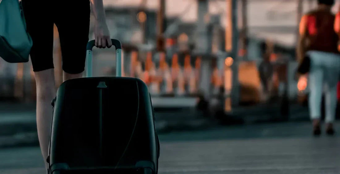 Person mit Koffer am Bahnhof