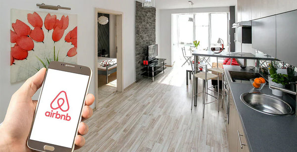 Handy mit Airbnb-App und Urlaubsunterkunft