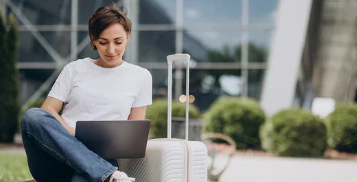 Frau mit Koffer und Laptop