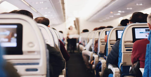 Flugzeugkabine mit weißen Sitzen und Passagieren