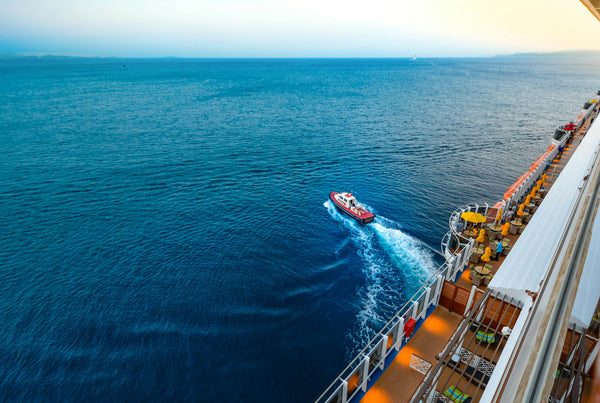 Sicht auf kleines Boot auf dem Meer von einem Kreuzfahrtschiff aus