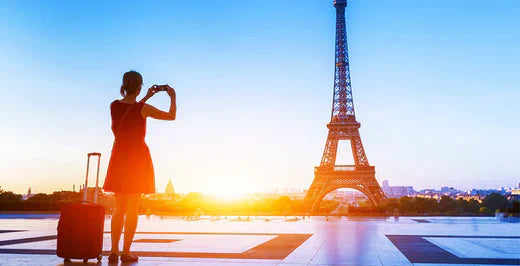Person mit einem Koffer von Bluestar vor dem Eiffelturm