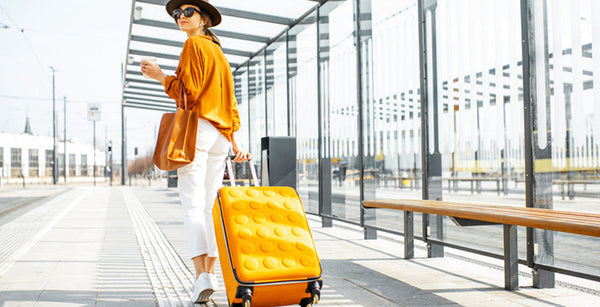 Frau am Flughafen mit einem Kabinenkoffer