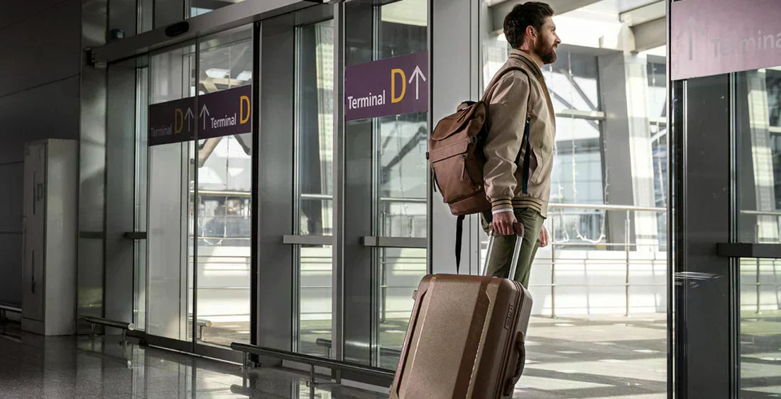 Mann mit Koffer am Flughafen